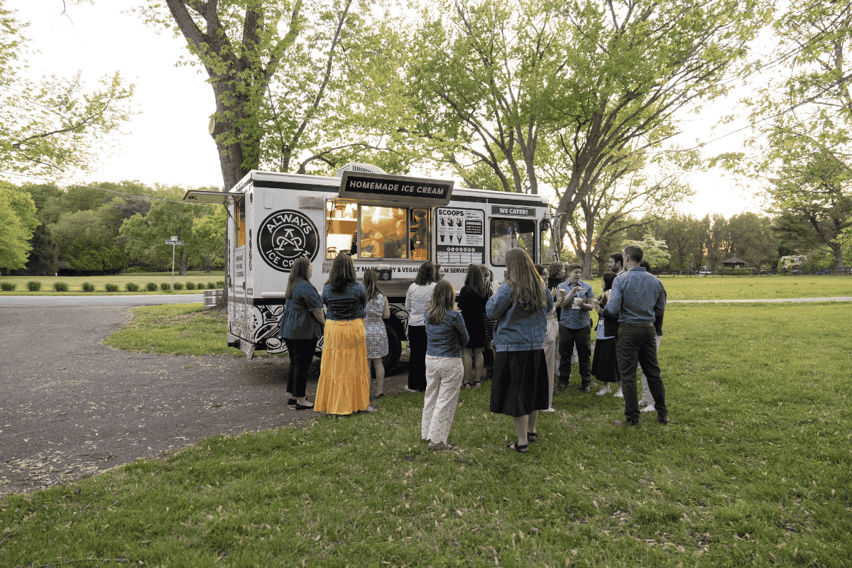 A group of people getting dessert at the ice cream truck.
