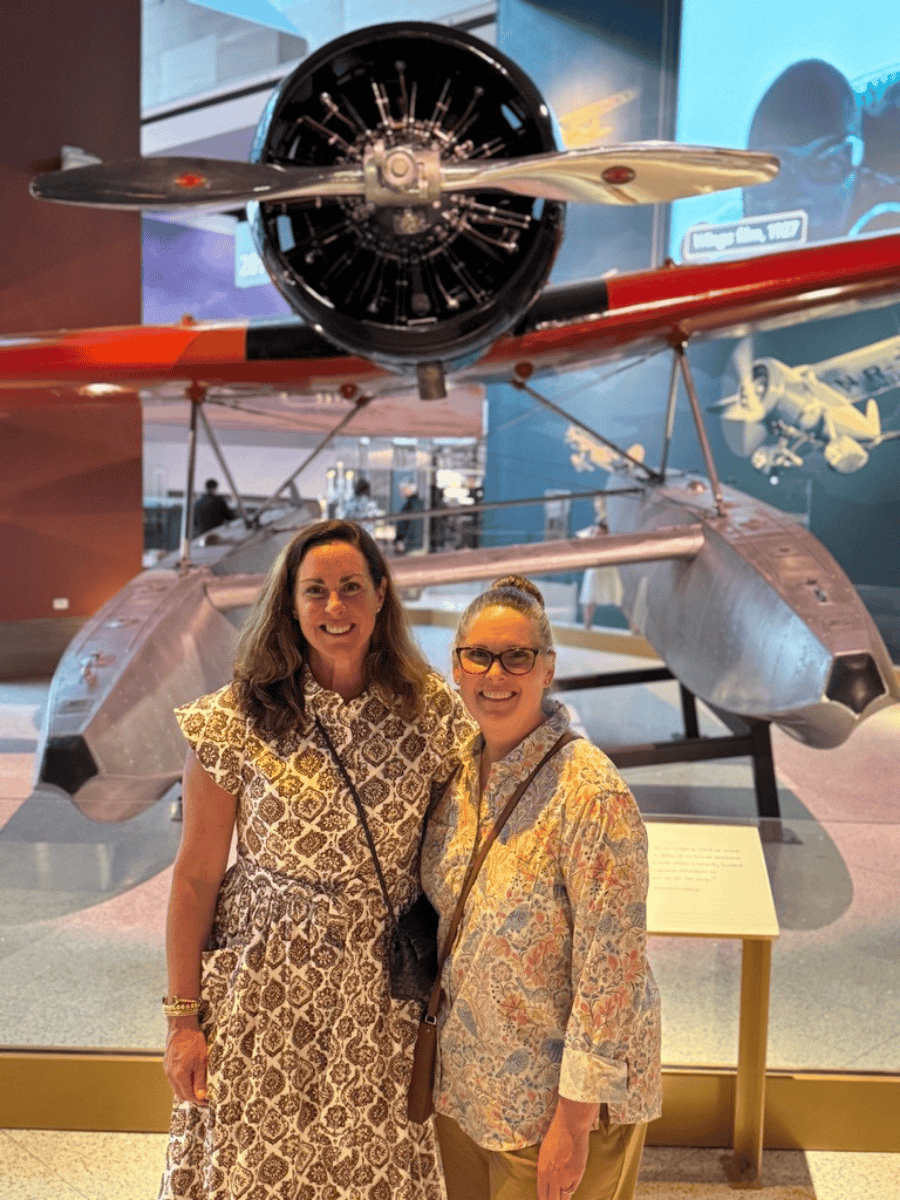 Allison and Aly pose in front of a plane inside the National Air and Space Museum.