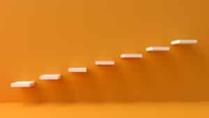 white steps rising on orange wall