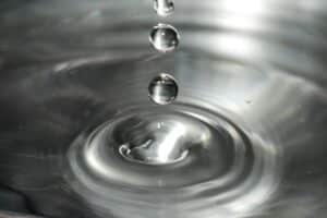 Water drop splash in a grey coloured dish